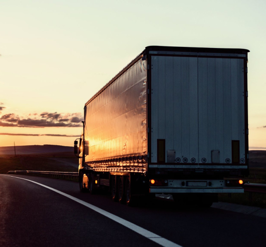 Фура на закате везет по трассе термозависимые грузы из Москвы. Biocard - перевозки грузов с температурным режимом по РФ, миру